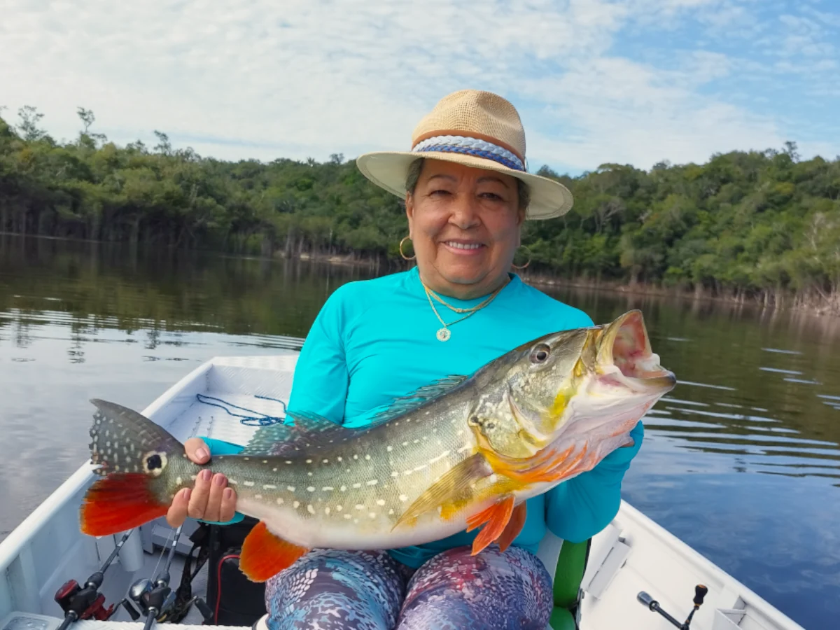 Cliente da Tucuna Turismo com tucunaré pescado na Amazônia